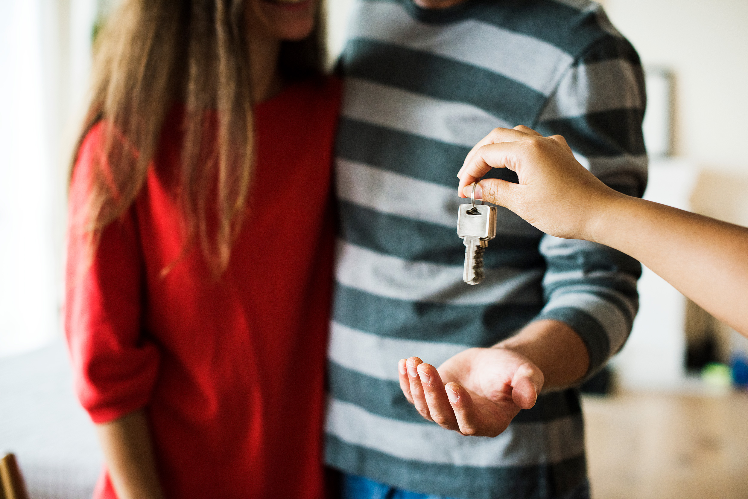 Couple recevant les clés de son logement après l’obtention de son prêt immobilier